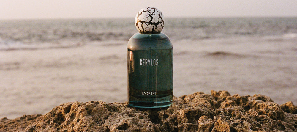 kerylos blue fragrance bottle on a beach 