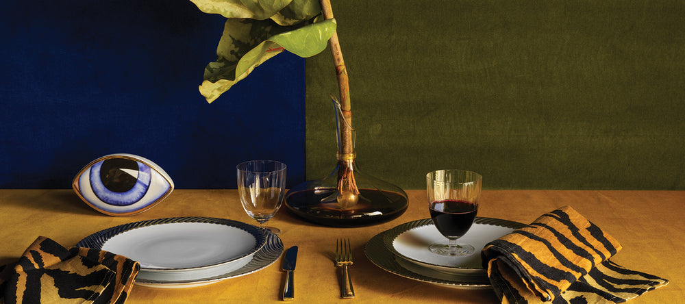 Table setting with a large leaf and decorative eye on a blue and green background