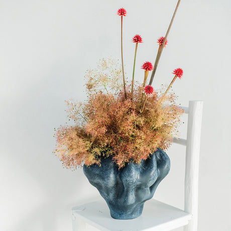Organic Shaped Vase with Florals on a white chair in front of a white wall