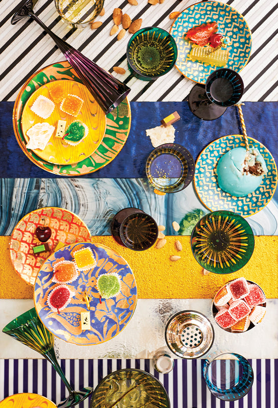 Colorful ceramic plates with various patterns on a striped tablecloth