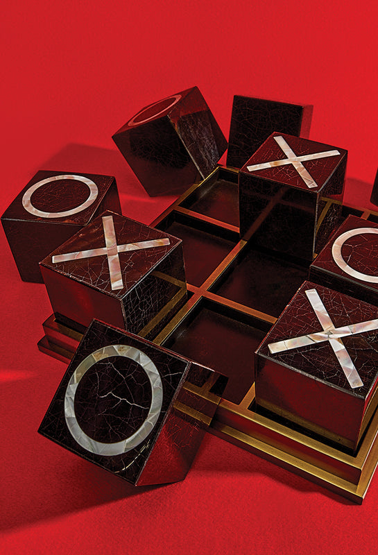 Luxury Tic Tac Toe Block Game with blocks arranged in a dynamic way in a red flat surface with dramatic cast shadow.