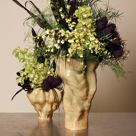 Two decorative vases with floral arrangements on a neutral background