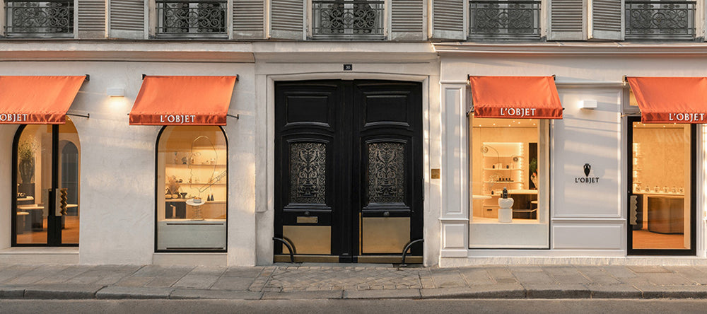 Discover L'OBJET Paris Flagship Store. Located at 30 Rue Jacob in Paris. Store front displayed with orange awnings and Brand Logo. 
