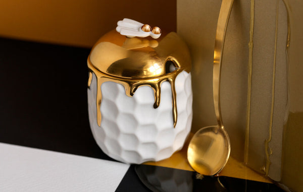 Porcelain beehive motif honeypot drizzled with gold resembling honey, winged bee finial and gold honey spoon. 