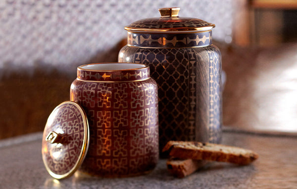 Earthenware canisters with Venetian textile surface designs in brown, red and gold.