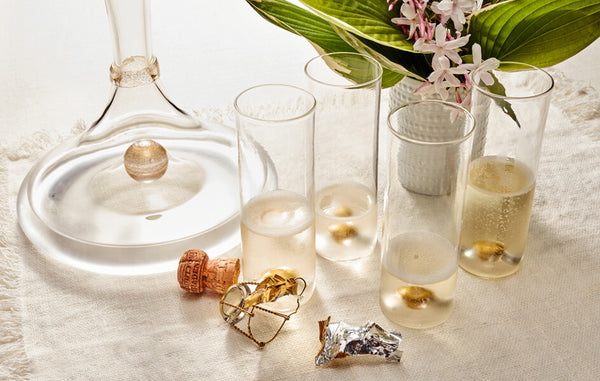 Glass pitcher and champagne glasses with gold-leaf orb inside the bottom of each piece.