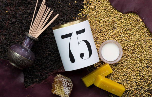 Porcelain candle vessel labeled with the number 75 arranged with honeycomb, beeswax and patchouli incense