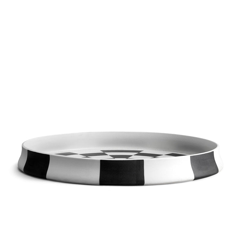 large, round black and white porcelain platter rim laid down