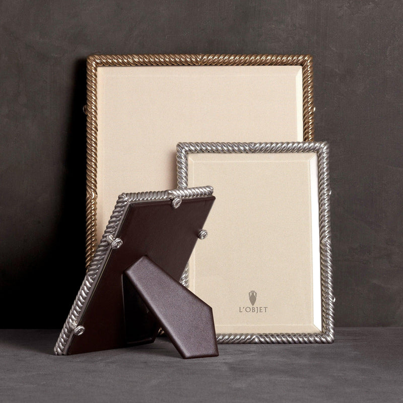 Group of gold and platinum twist-motif picture frames with leather backing and L'Objet logo.