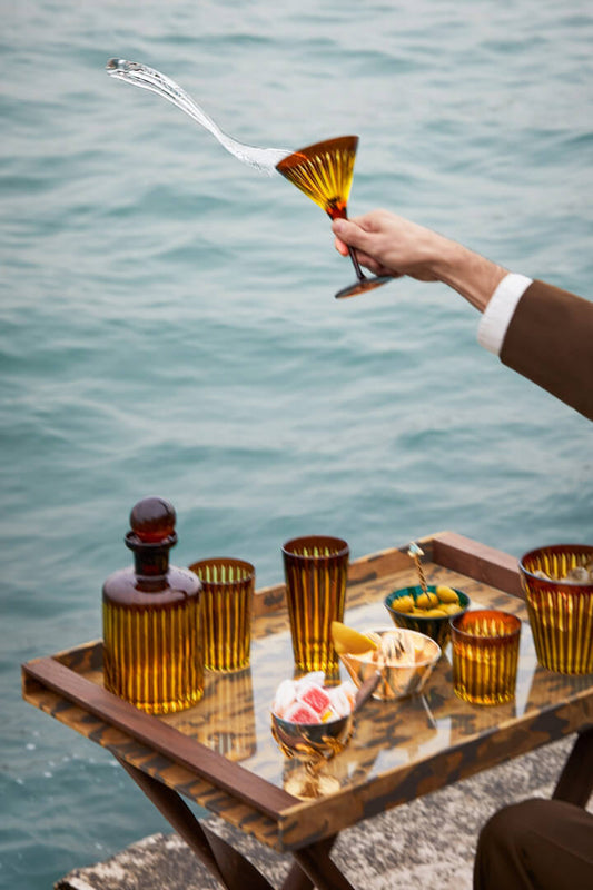 L'OBJET Fortuny and Prism. Man throwing liquid from Prism Glass into venice canal.