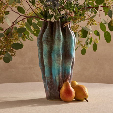 Vase with greenery and pears on a neutral background