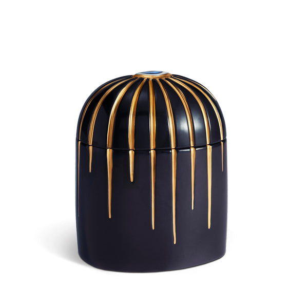 Dark blue cylinder candle posed from side to show gold drip details from eye motif