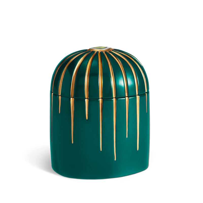 Dark green cylinder candle posed from side to show gold drip details from eye motif
