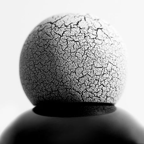 Round Sphere Wooden White Crackled Fragrance Bottle Top with a peak of a black porcelain bottle with stark white background.