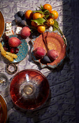 Dinnerware setting with Fortuny tapestry mixed patterns, fruit, gold star motif napkin ring