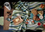 Table set with blue green landscape pattern tablecloth, Green round placemats, stone glazed terra oval platter