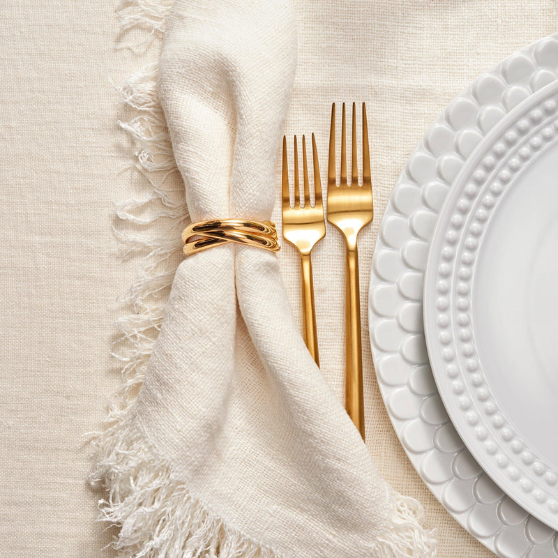 Dinnerware setting with Aegean white pattern, white napkin, gold 3-ring napkin ring