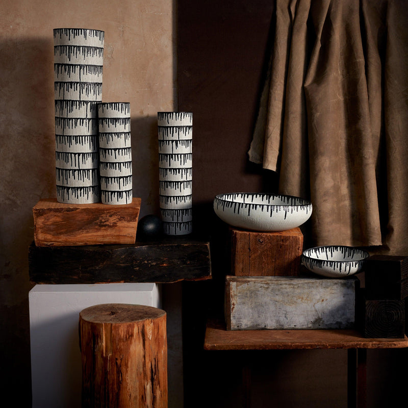 Group of handmade porcelain decorative bowls and vases with indigo dye drops to flowing down from the rim.