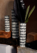 Group of handmade porcelain decorative bowls and vases with indigo dye drops to flowing down from the rim.